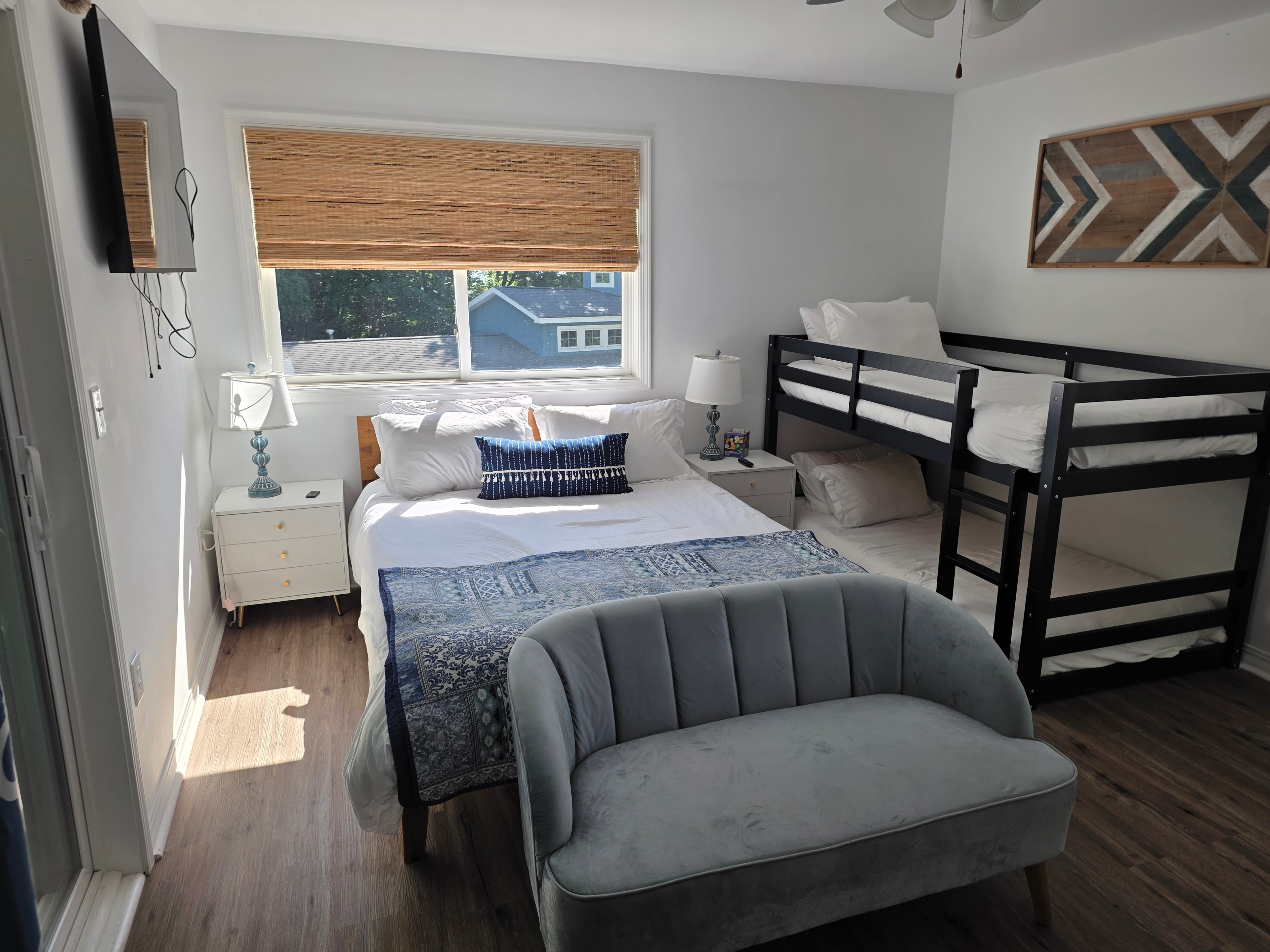 Bedroom with queen bed, bunk bed, and gray accent chair